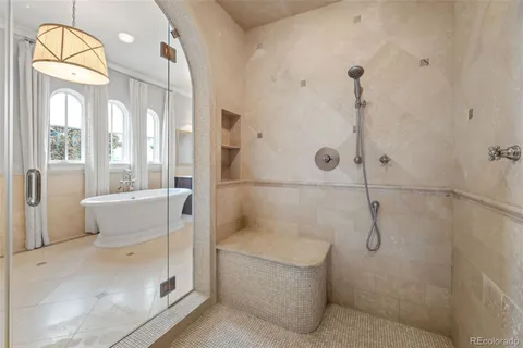 a bathroom with a granite countertop bathtub shower sink and mirror