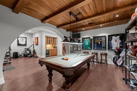 a living room with furniture pool table and chairs