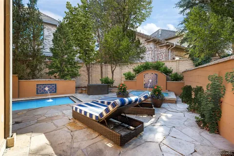 a view of patio with chairs and table under an umbrella