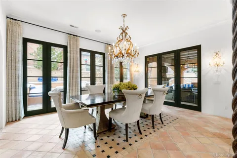 a dining room with furniture a chandelier and window