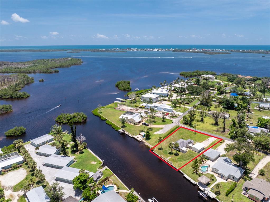 an aerial view of ocean and residential houses with outdoor space