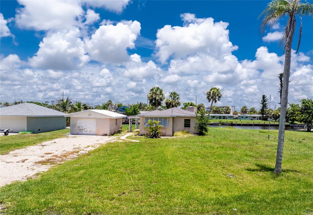 1899 Riverside Drive Englewood, FL 34223 - Photo 2 of 20 a view of a house with a big yard and potted plants