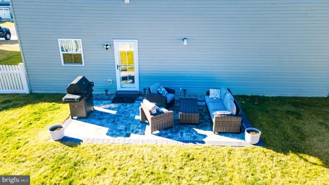 a view of a backyard with table and chairs potted plants