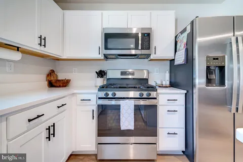 a kitchen with stainless steel appliances granite countertop a refrigerator stove top oven a sink and dishwasher