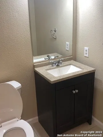 a bathroom with a sink a toilet and mirror