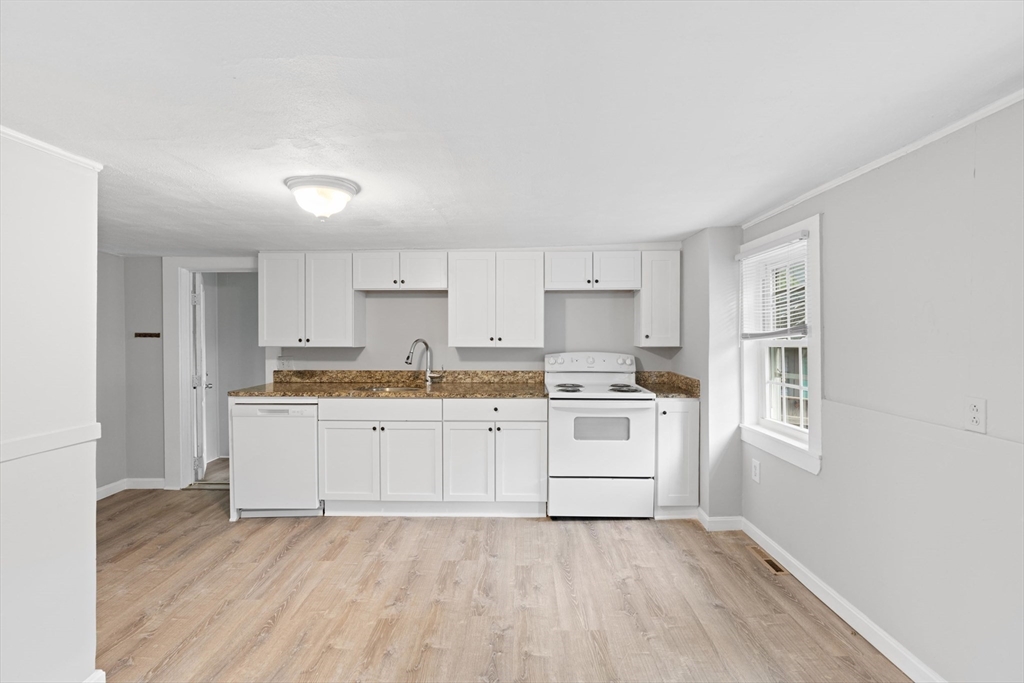 95 South Main Street, Unit B Andover, MA 01810 - Photo 11 of 34 a kitchen with granite countertop white cabinets and white appliances