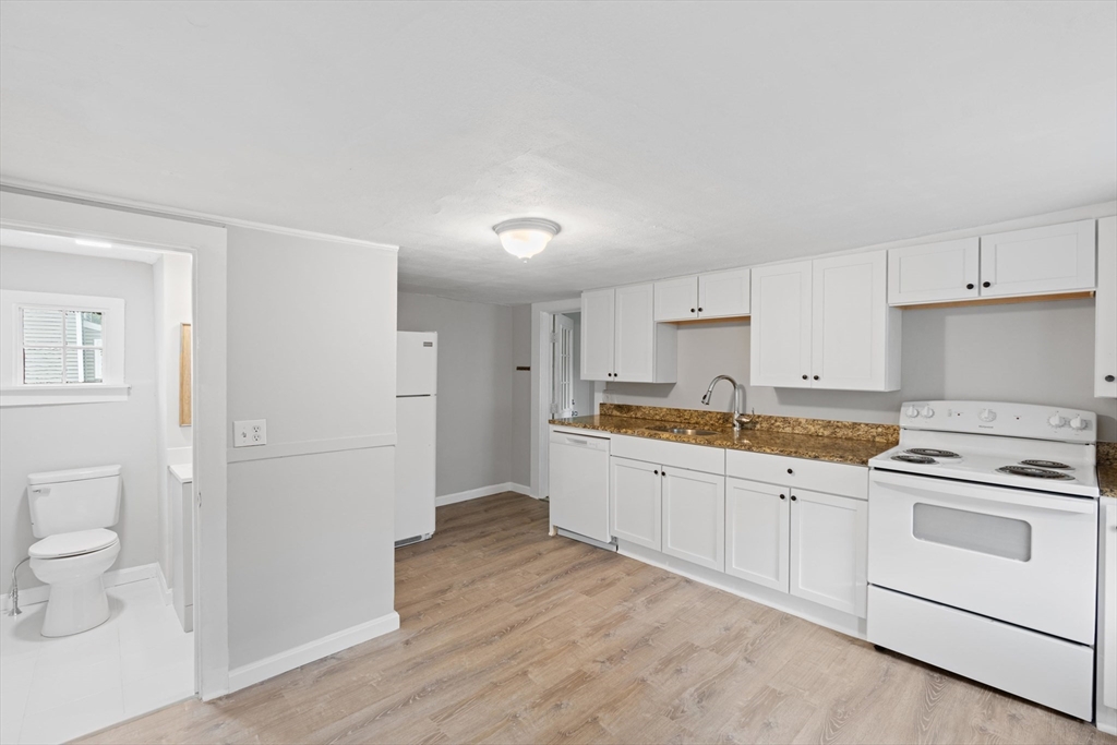 95 South Main Street, Unit B Andover, MA 01810 - Photo 12 of 34 a kitchen with granite countertop white cabinets and white appliances