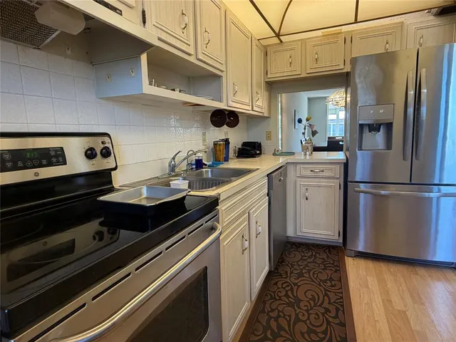 a kitchen with stainless steel appliances a sink stove and refrigerator