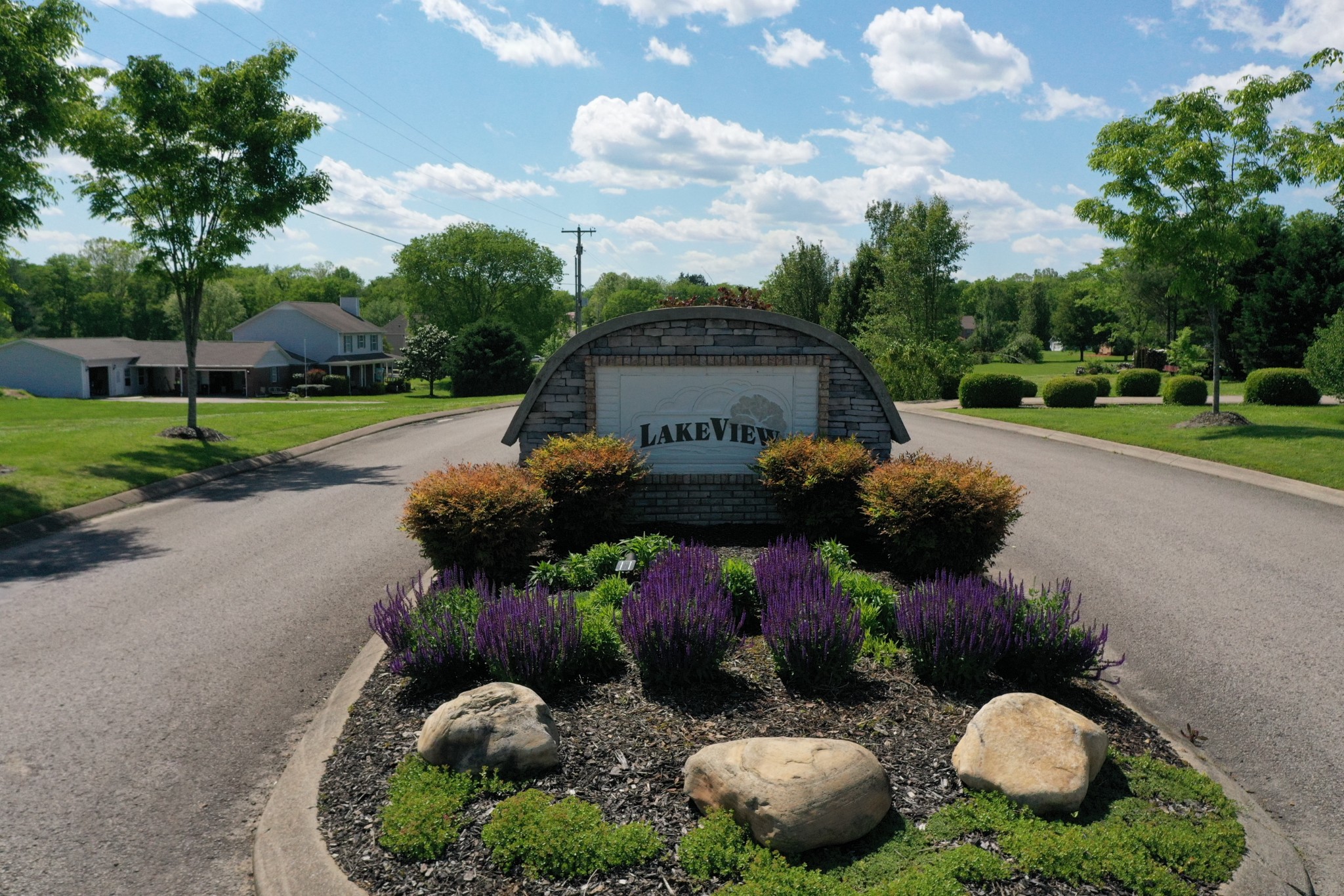 a backyard of a house with lots of green space and lake view