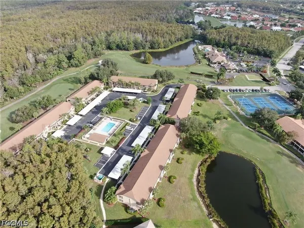 an aerial view of a house with a yard and lake