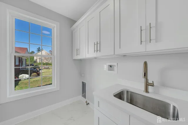 a kitchen with stainless steel appliances granite countertop a sink and a white cabinets