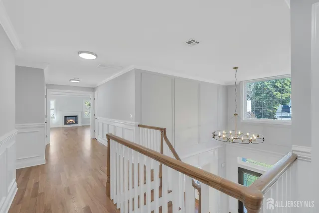 a view of a hallway with wooden floor and staircase