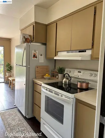 a kitchen with a sink a refrigerator and a stove top oven