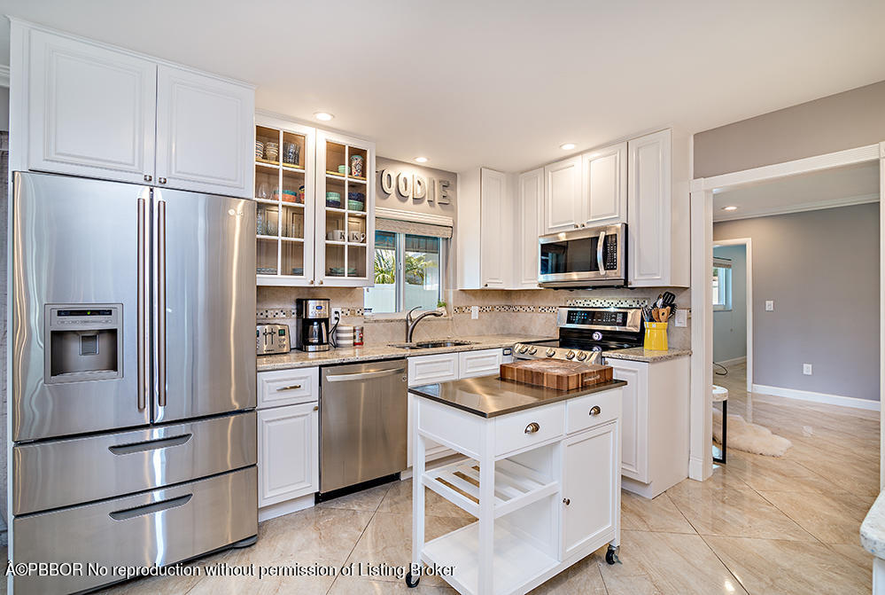 2285 Palm Road West Palm Beach, FL 33406 - Photo 9 of 27 a kitchen with white cabinets and stainless steel appliances