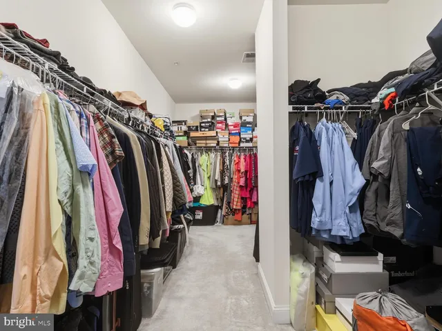a view of walk in closet with clothes
