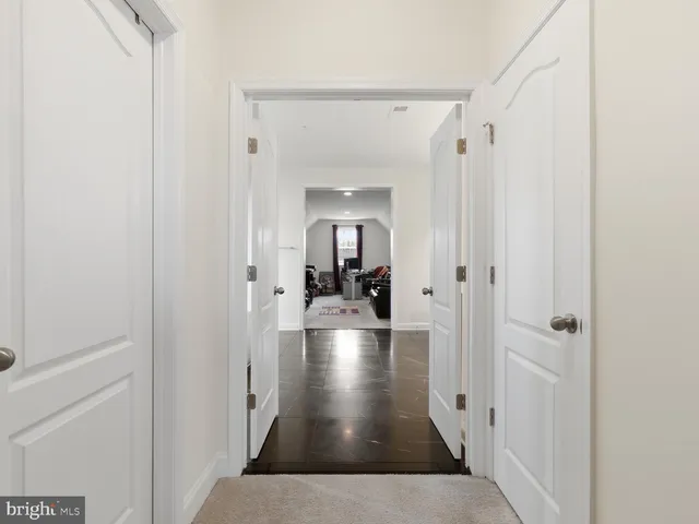 a view of a hallway with a livingroom and furniture