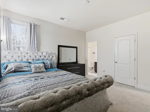 a bedroom with a large bed and a dresser