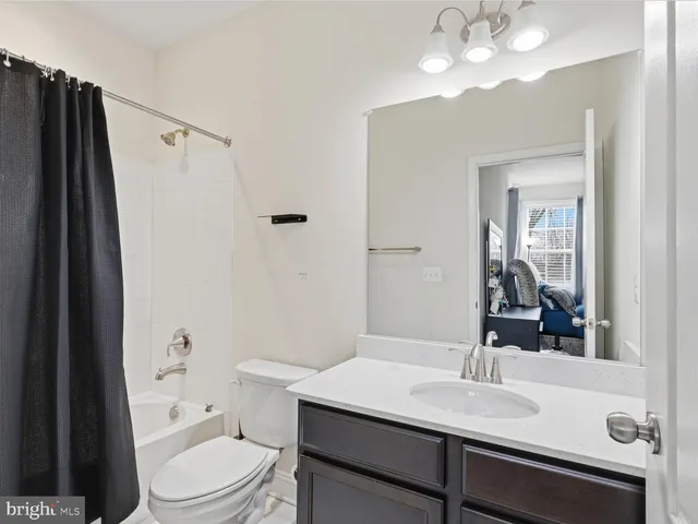 a bathroom with a sink a toilet a mirror and shower