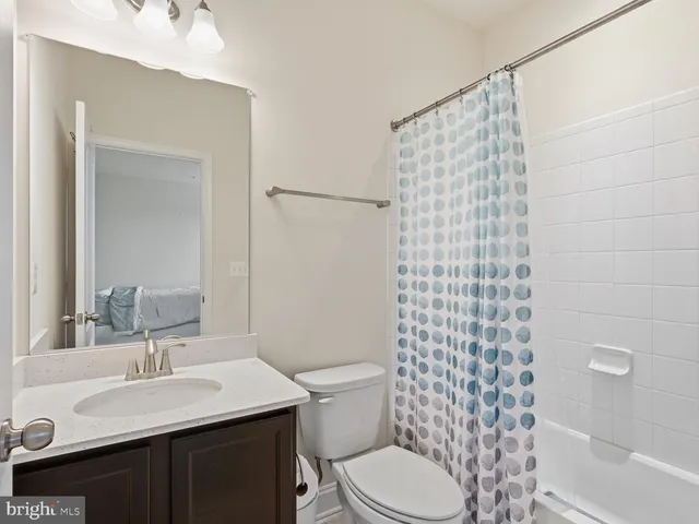 a bathroom with a sink a toilet and shower curtain