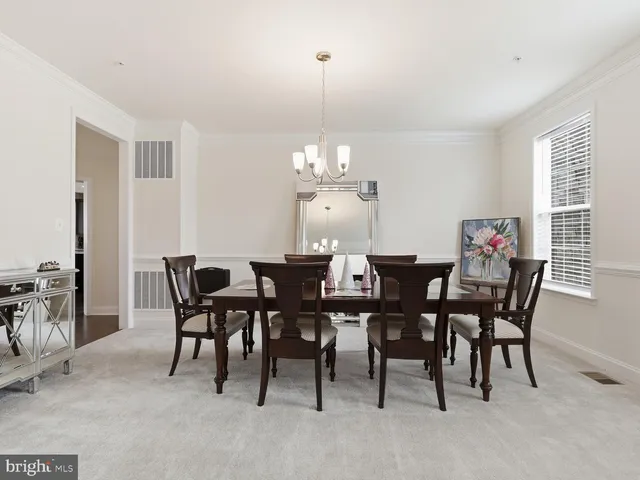 a view of a dining room with furniture and chandelier