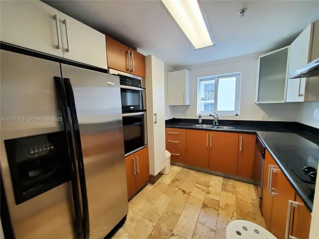 a kitchen with stainless steel appliances granite countertop a sink stove and cabinets