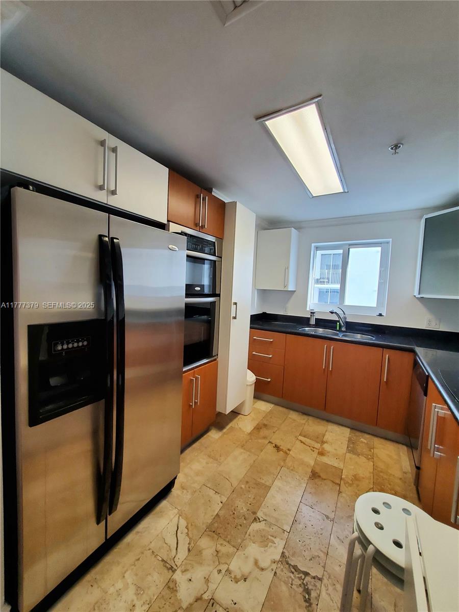 170 Southeast 14th Street, Unit 2705 Miami, FL 33131 - Photo 25 of 41 a kitchen with stainless steel appliances kitchen island granite countertop a refrigerator and a sink