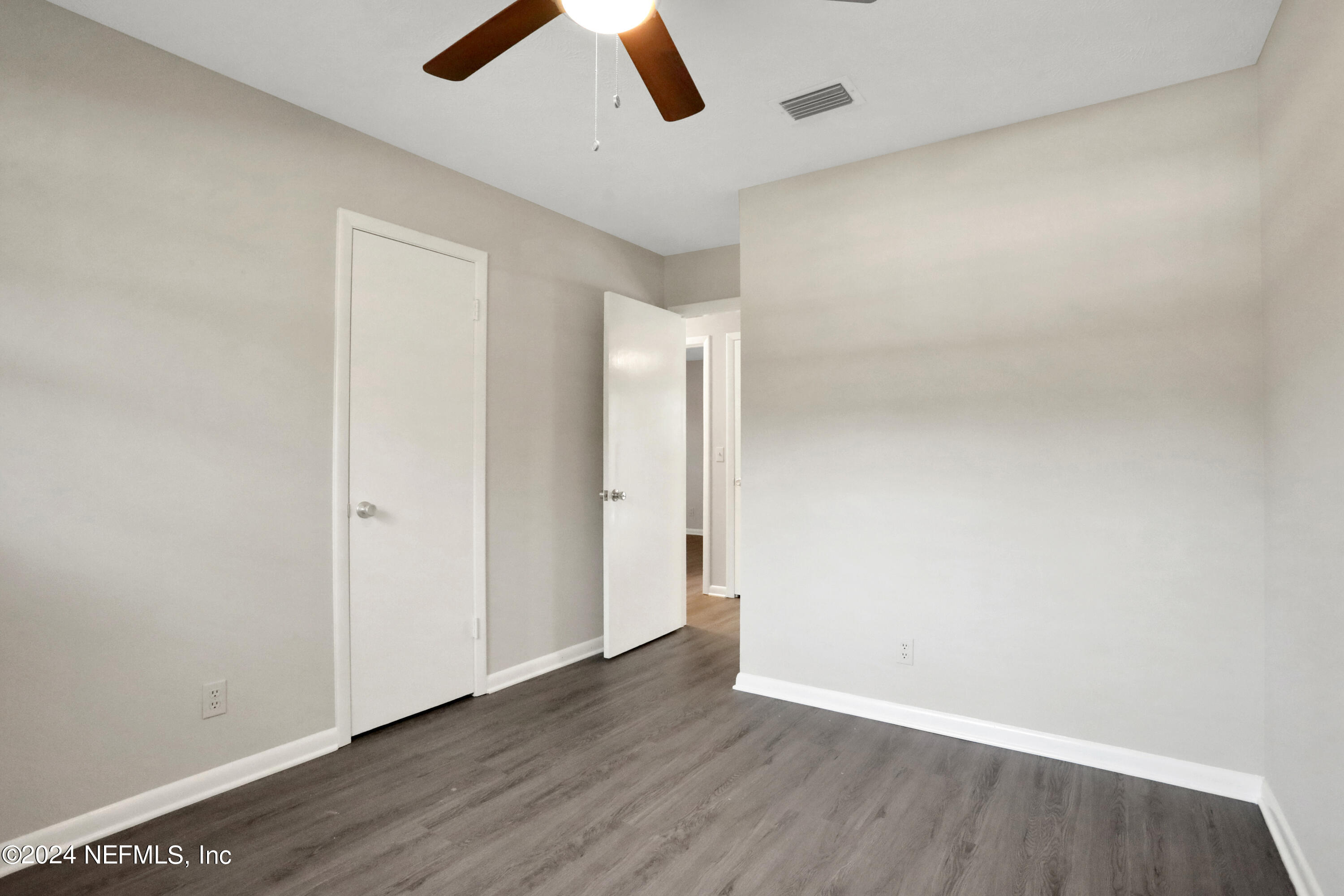 3211 Victoria Park Road Jacksonville, FL 32216 - Photo 12 of 25 an empty room with wooden floor and windows