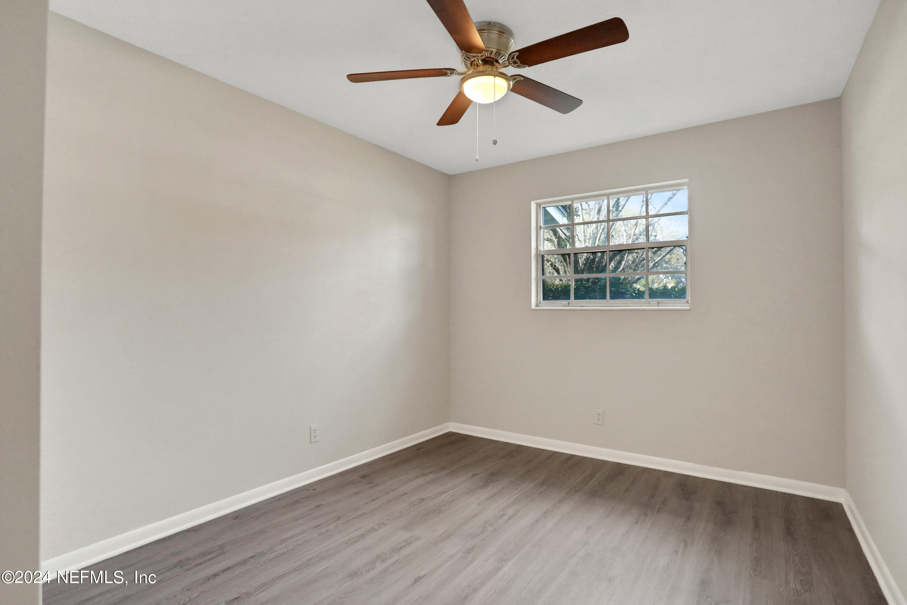 3211 Victoria Park Road Jacksonville, FL 32216 - Photo 13 of 25 an empty room with wooden floor and windows