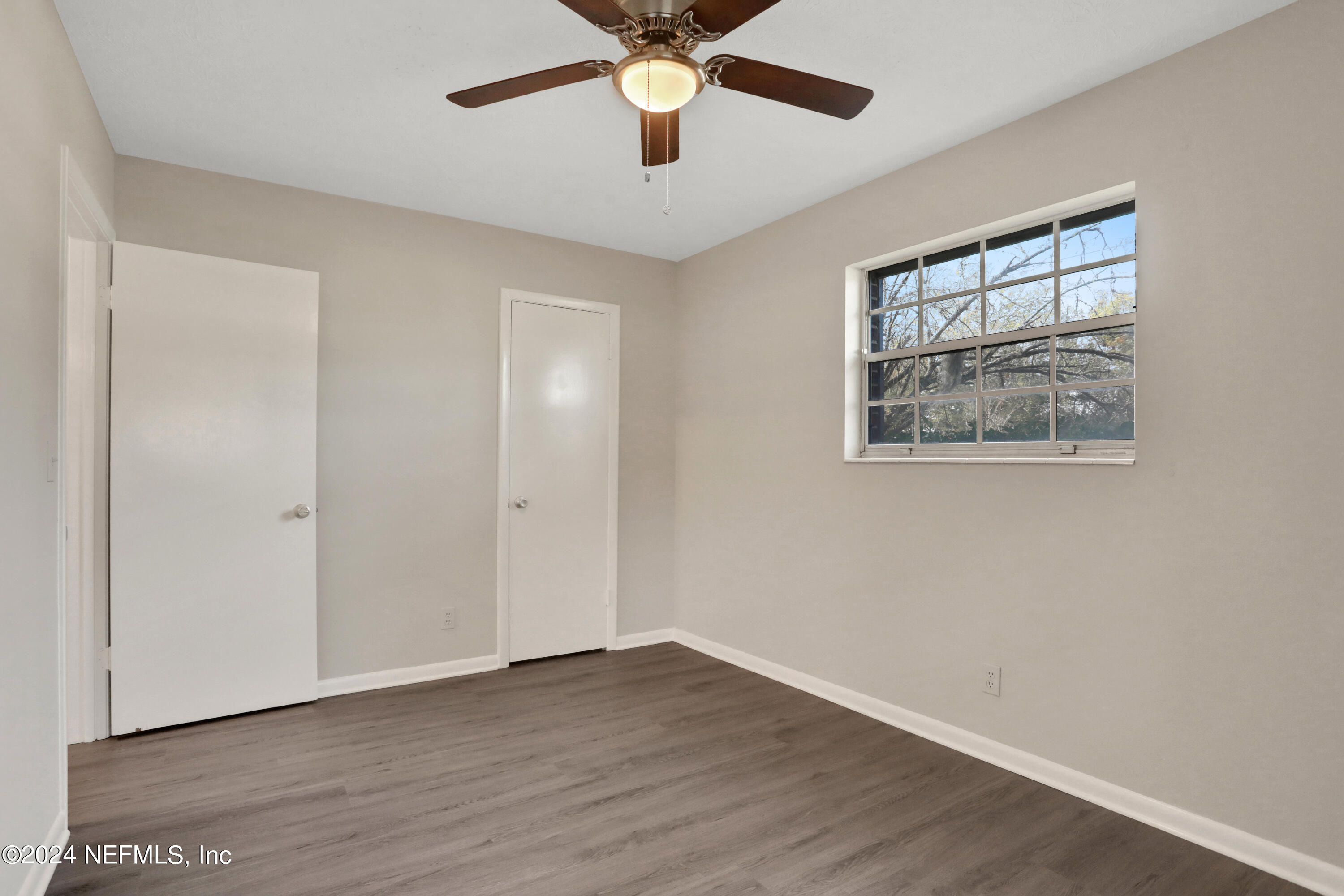 3211 Victoria Park Road Jacksonville, FL 32216 - Photo 14 of 25 a view of an empty room with window and wooden floor
