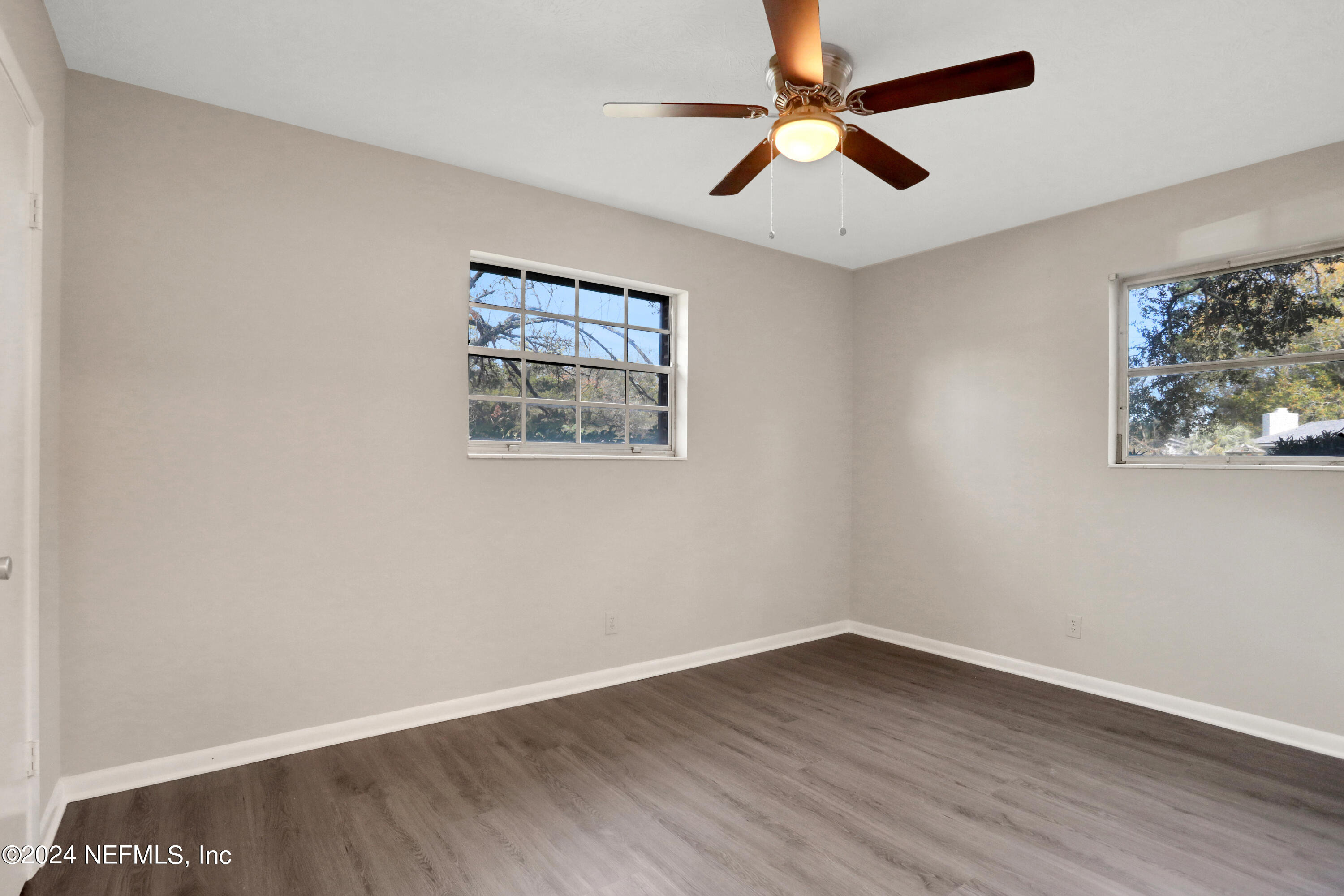 3211 Victoria Park Road Jacksonville, FL 32216 - Photo 15 of 25 an empty room with wooden floor and ceiling fan