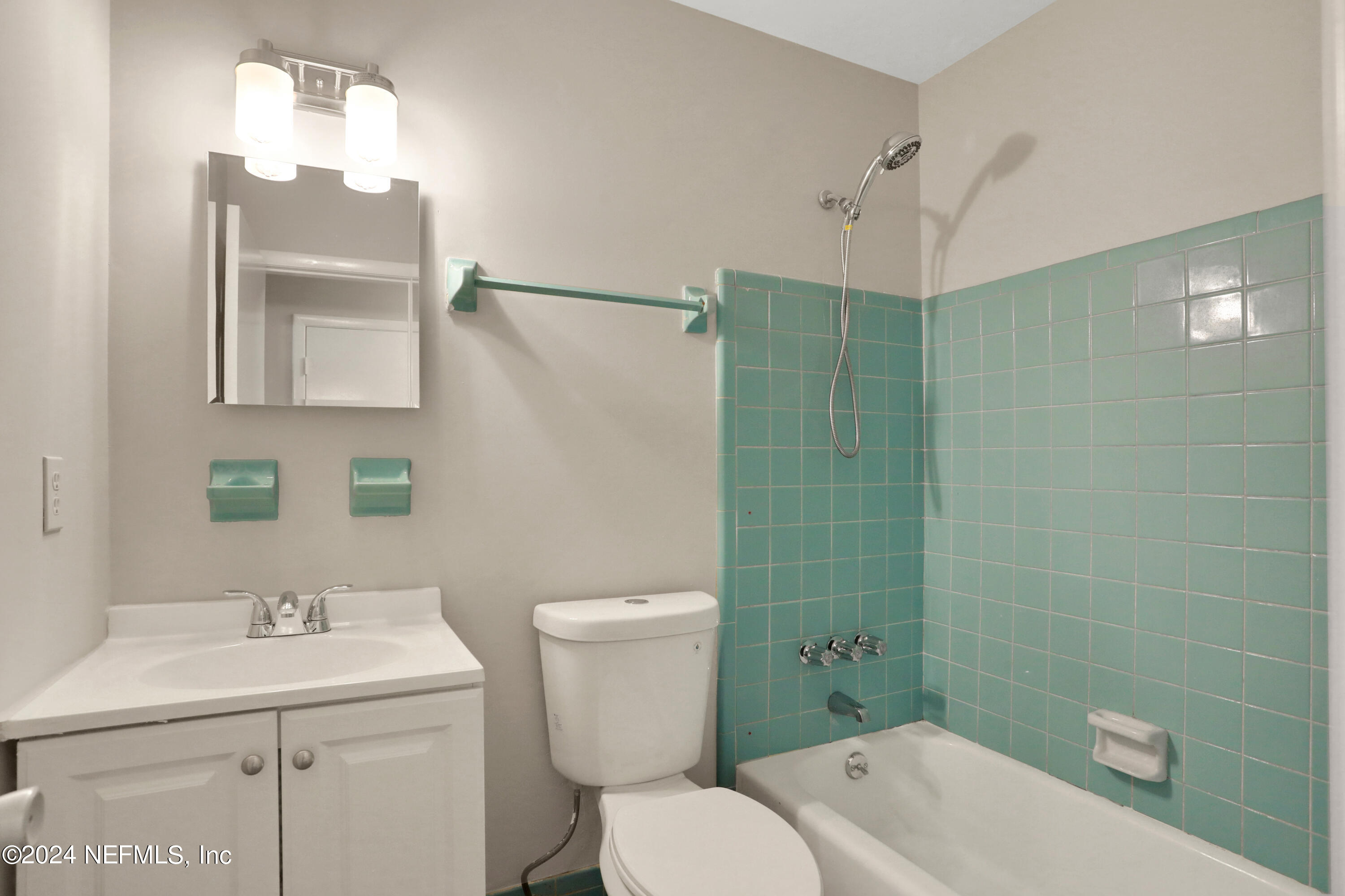 3211 Victoria Park Road Jacksonville, FL 32216 - Photo 16 of 25 a bathroom with a toilet sink vanity and mirror