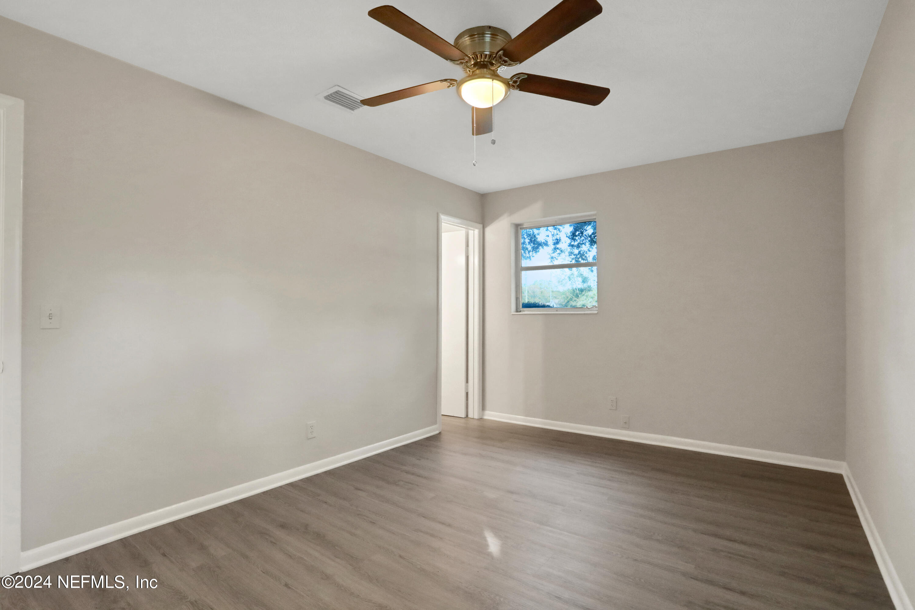 3211 Victoria Park Road Jacksonville, FL 32216 - Photo 17 of 25 an empty room with wooden floor and windows