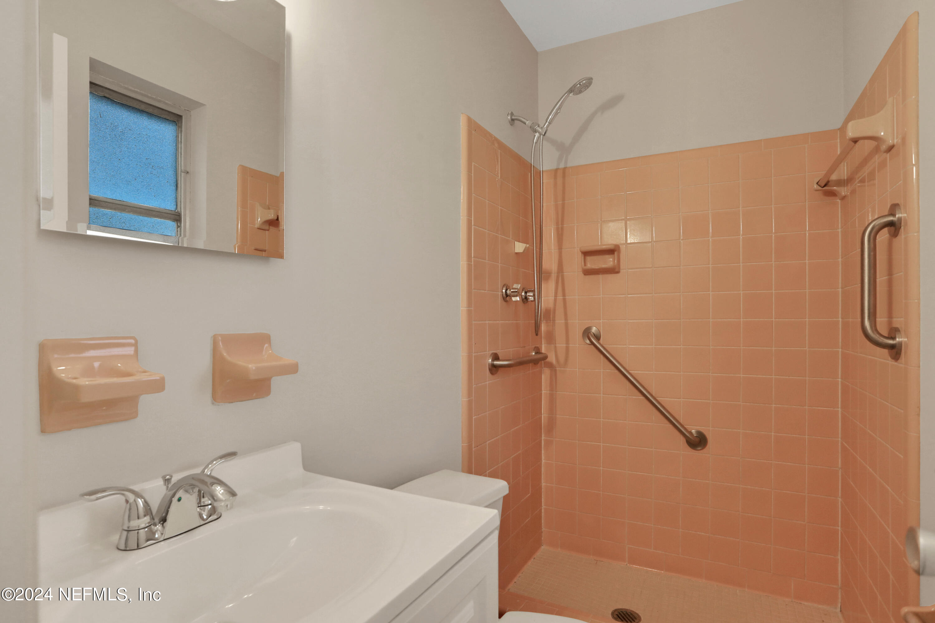 3211 Victoria Park Road Jacksonville, FL 32216 - Photo 18 of 25 a bathroom with a sink and a mirror