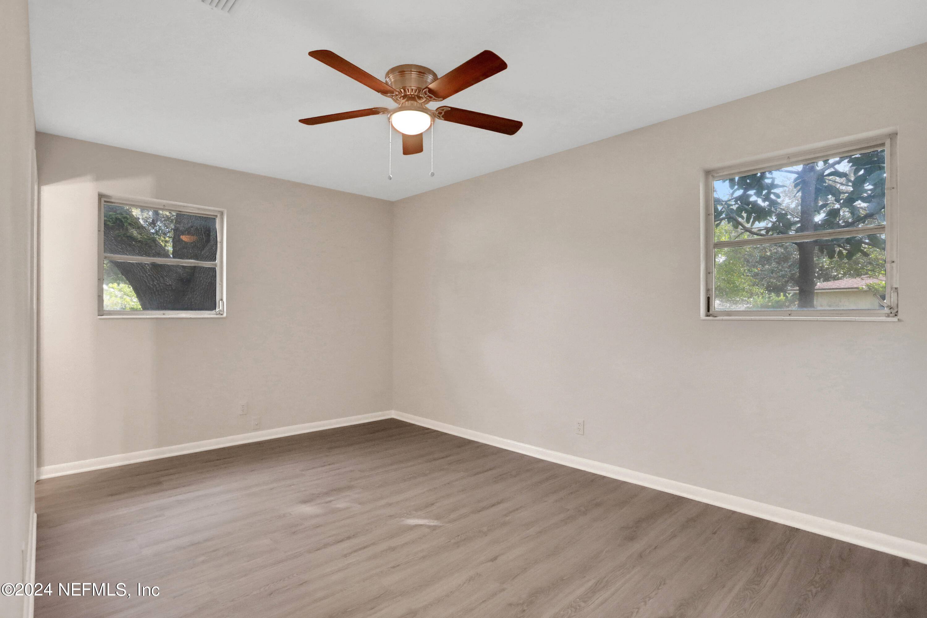 3211 Victoria Park Road Jacksonville, FL 32216 - Photo 20 of 25 an empty room with wooden floor and windows