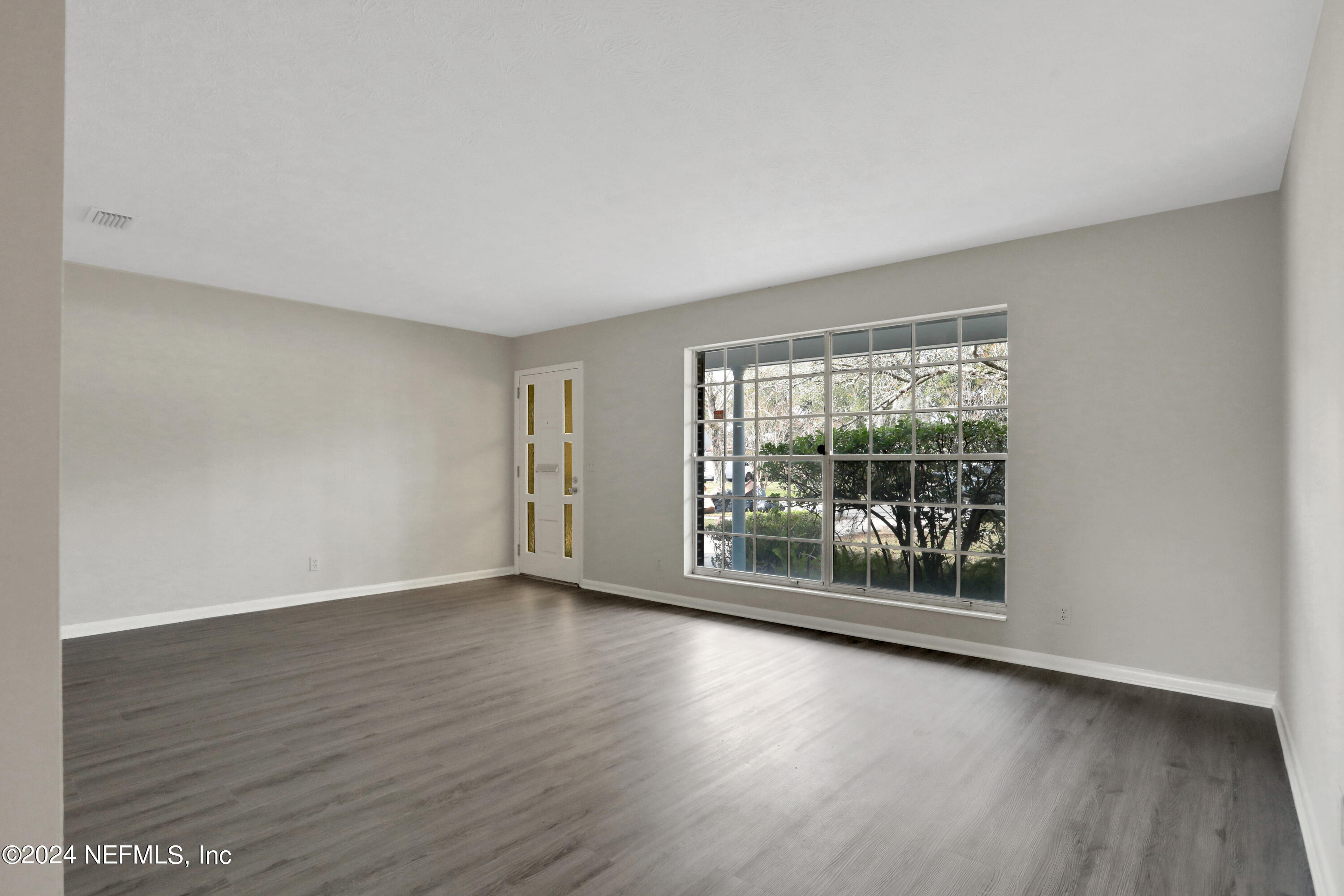 3211 Victoria Park Road Jacksonville, FL 32216 - Photo 4 of 25 a view of a room with wooden floor and window
