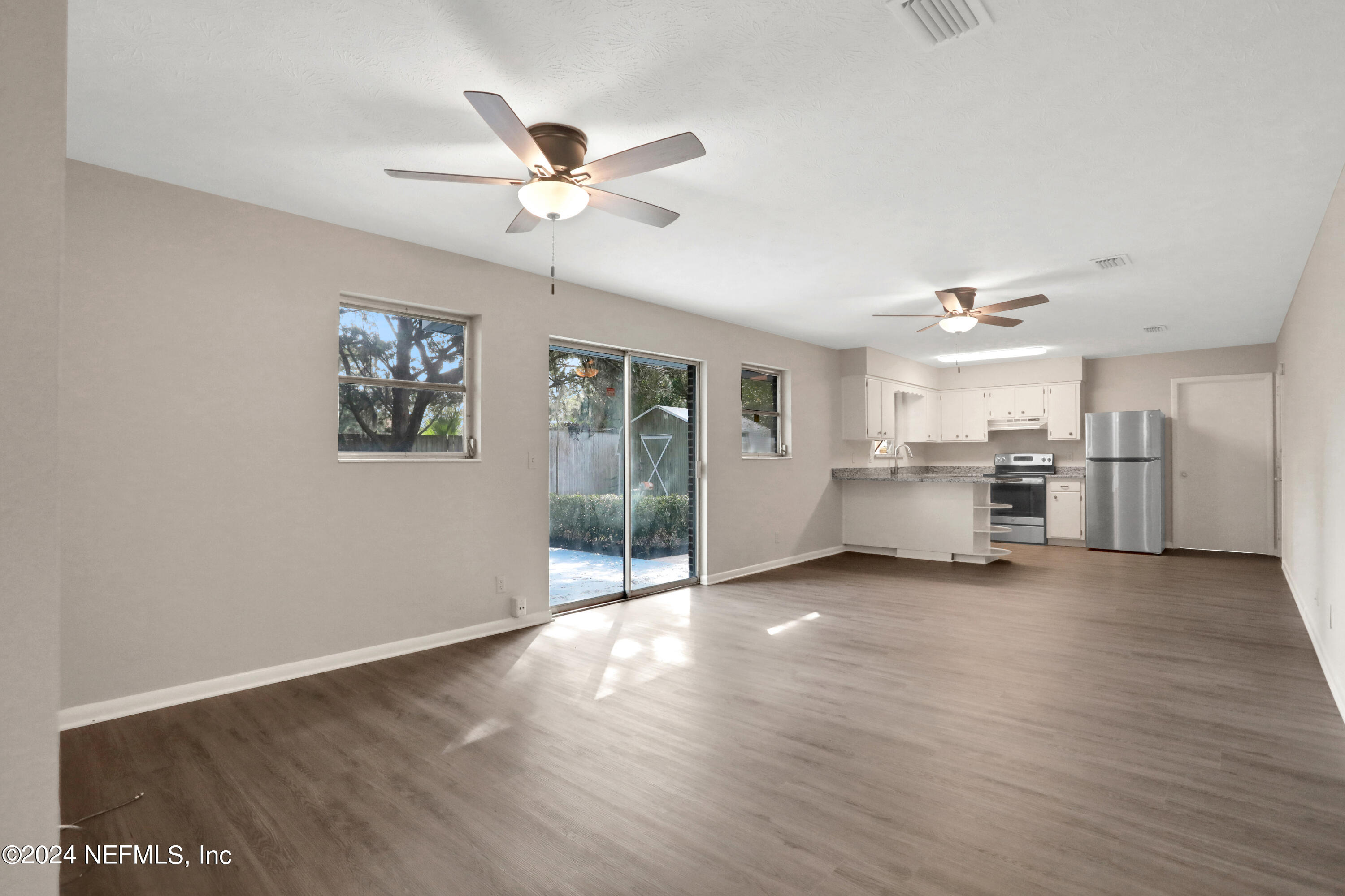3211 Victoria Park Road Jacksonville, FL 32216 - Photo 7 of 25 a view of a livingroom with furniture a ceiling fan and wooden floor