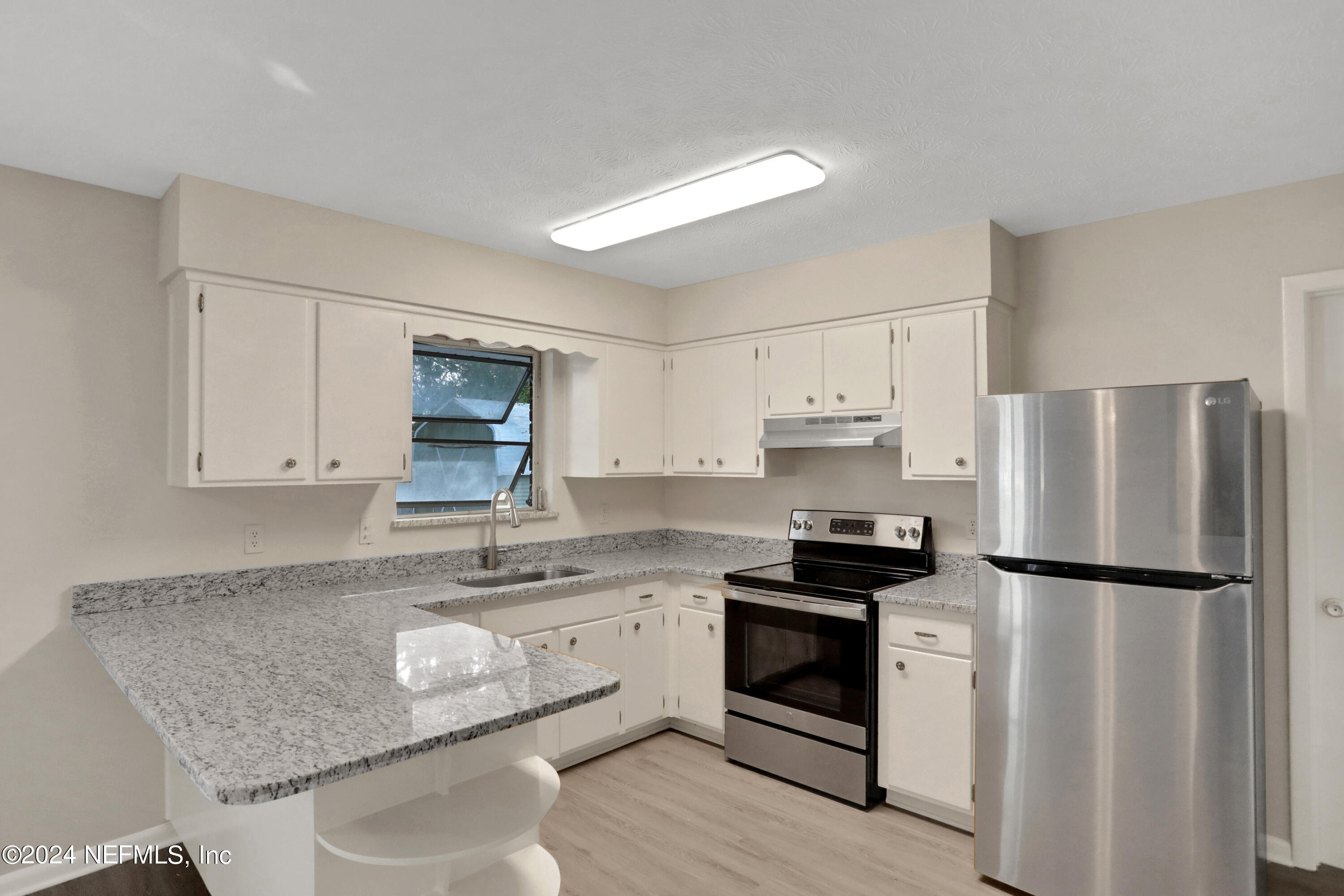 3211 Victoria Park Road Jacksonville, FL 32216 - Photo 8 of 25 a kitchen with granite countertop a refrigerator stove top oven and sink