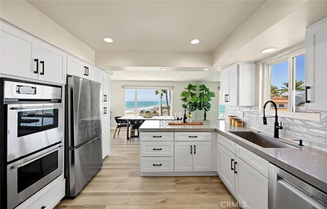 a kitchen with white cabinets and appliances