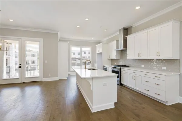 a kitchen with white cabinets and wooden floors