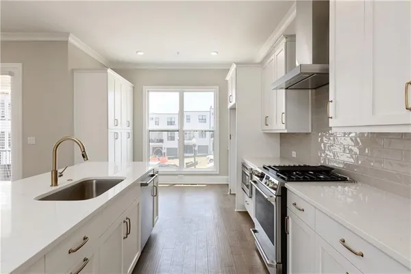 a kitchen that has a sink and a stove top oven