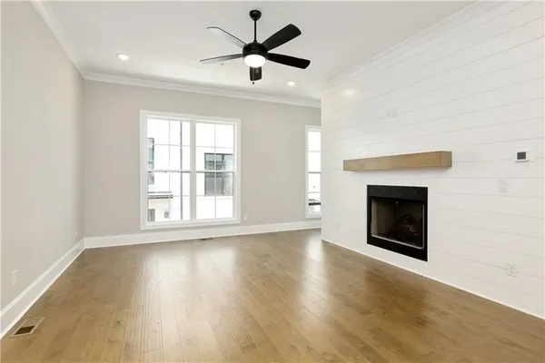 an empty room with windows fireplace and a sink