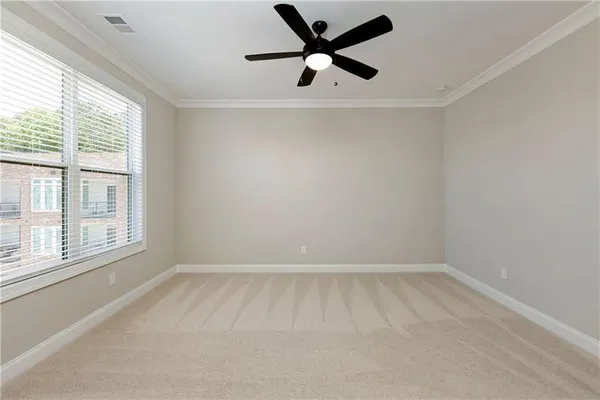 an empty room with a window and a fan