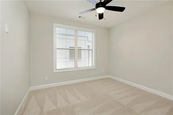 an empty room with a window and a fan