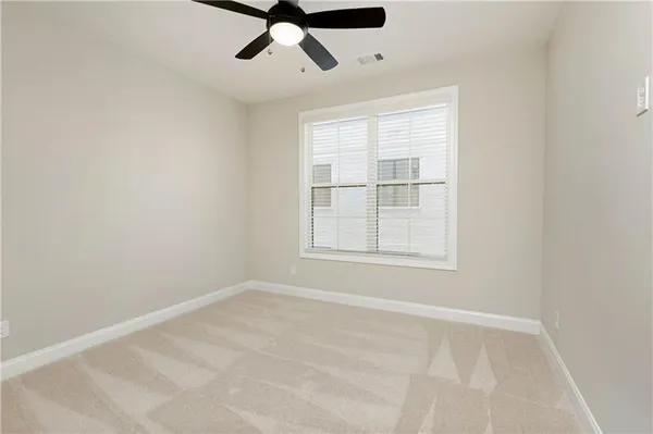 an empty room with windows and fan