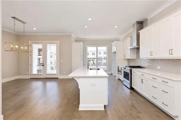 a large kitchen with stainless steel appliances granite countertop a lot of counter space and wooden floors