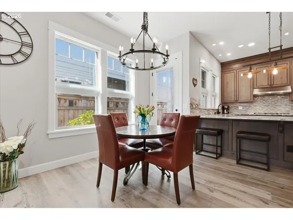 a open kitchen with granite countertop a dining table chairs and wooden floor