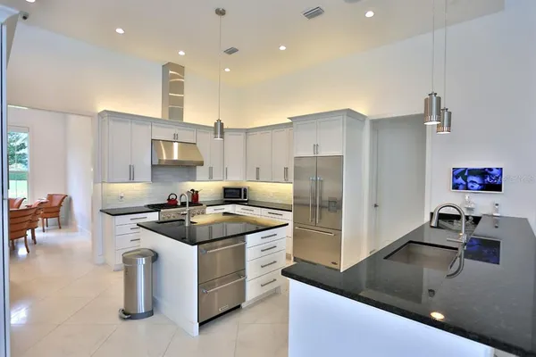 a kitchen with stainless steel appliances granite countertop a sink stove and refrigerator