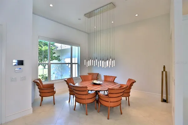 a dining room with furniture and a floor to ceiling window
