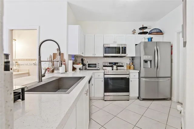 a kitchen with a refrigerator sink and cabinets