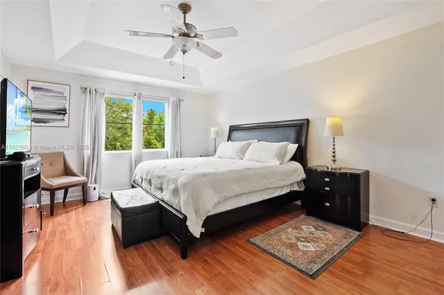 a large bedroom with a bed and wooden floor